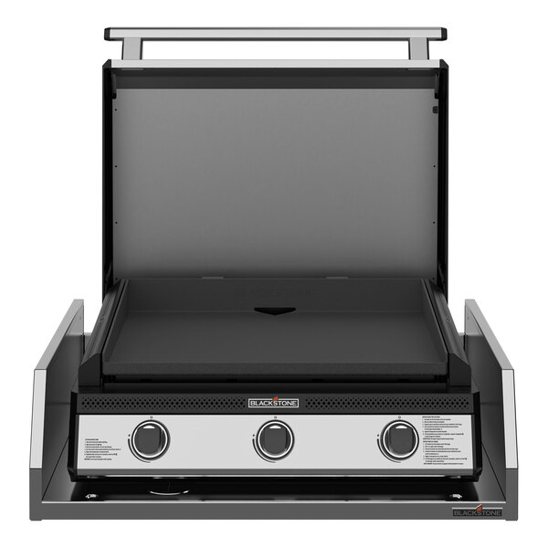 A Blackstone black and silver outdoor kitchen griddle with a lid.