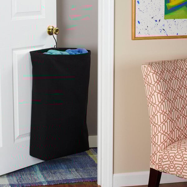 A black canvas laundry bag hanging from a door.