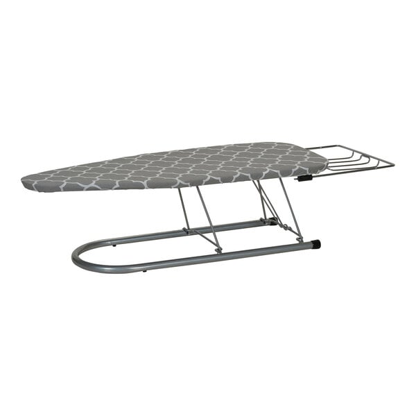 A Household Essentials Tabletop steel mesh ironing board with a trellis cover and iron rest on a table.