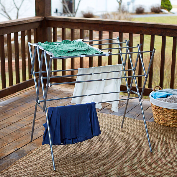 A Household Essentials silver collapsible steel drying rack on a porch.