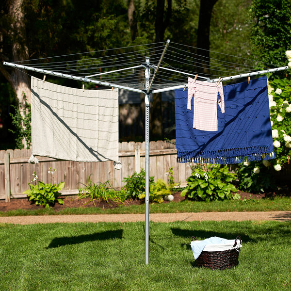 A Household Essentials dual height outdoor umbrella drying rack with clothes drying on it.