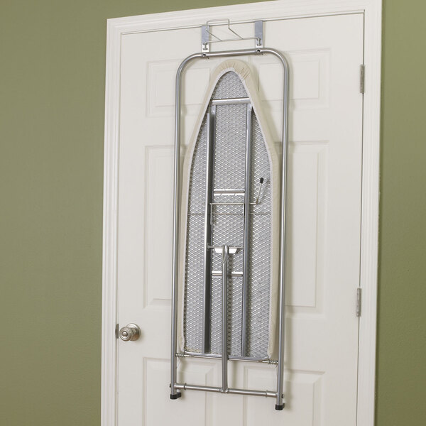 A white steel mesh ironing board with a cotton cover and iron holder hanging on a door.