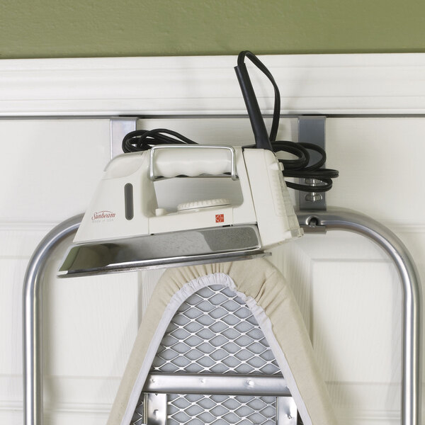A Household Essentials over-the-door ironing board with an iron on it.