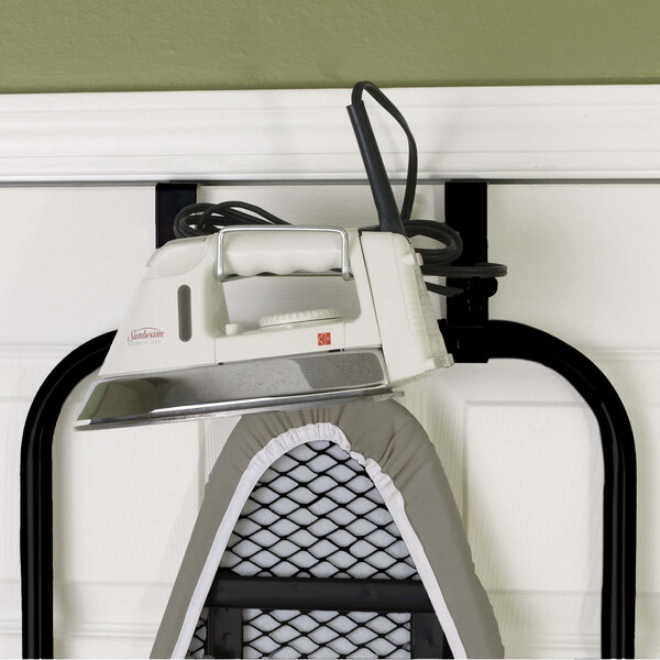 A black Household Essentials steel mesh ironing board with an iron on it.