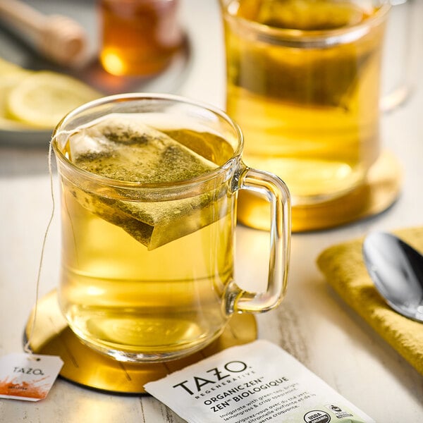 A glass mug of Tazo Organic Zen Green Tea with a bag in it.