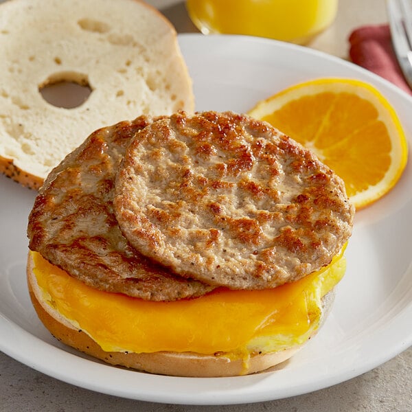 A breakfast sandwich with a turkey sausage patty and eggs on a white plate.