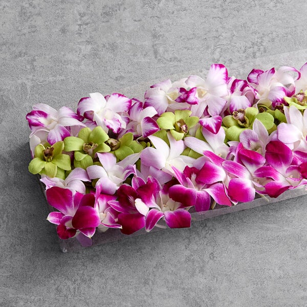 A box of mixed color orchids on a table.