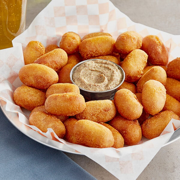 A plate of Nathan's Famous Mini Corn Dog Nuggets with a dipping sauce.