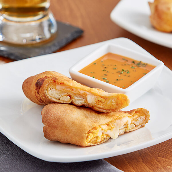 A Pizzeria Uno Buffalo Chicken Calzone on a plate with a drink.