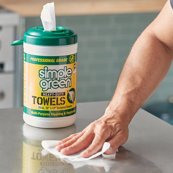 A hand using a Simple Green Heavy-Duty Cleaning Towel to wipe a counter.