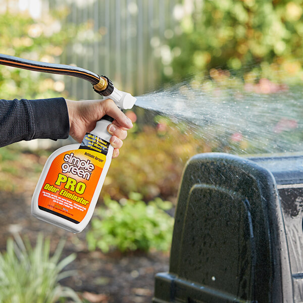 A person holding a bottle of Simple Green Pro Citrus Scented Odor Eliminator.