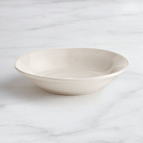 An Acopa Highlands white china bowl on a marble surface.
