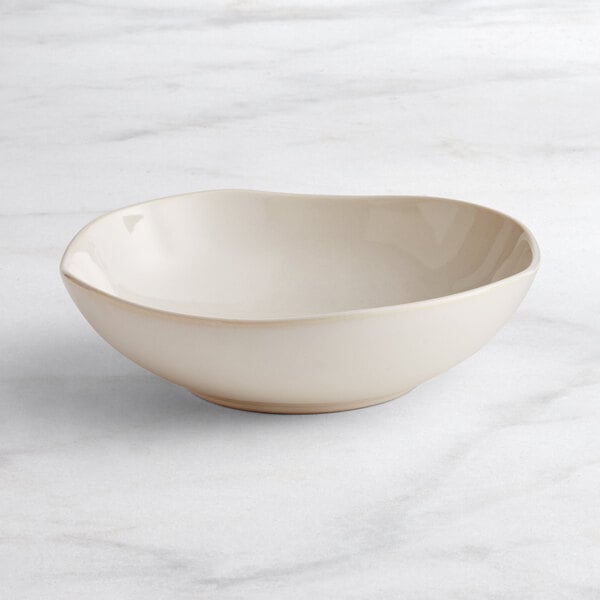 An Acopa Highlands white china bowl on a white marble surface.