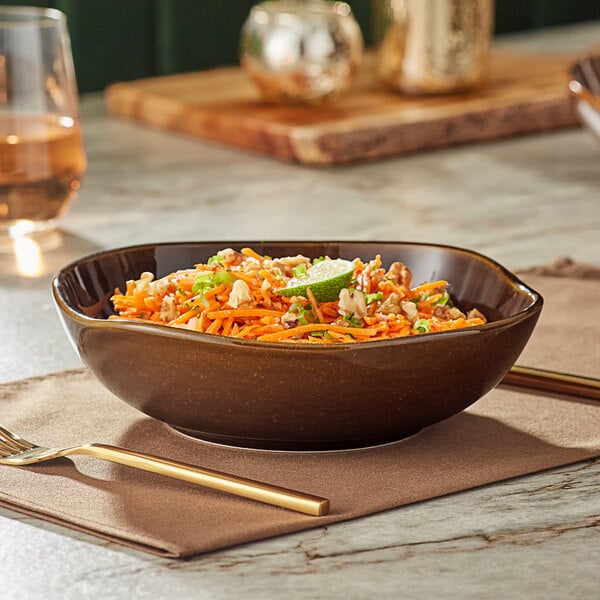 An Acopa Highlands round china bowl filled with food on a table with a glass and a fork.