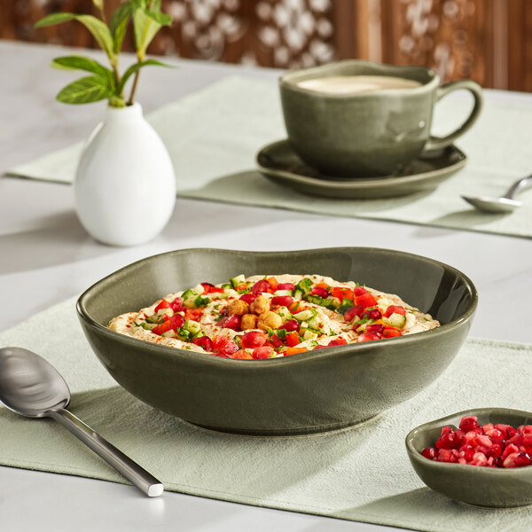 An Acopa Highlands juniper green china bowl filled with food on a table.