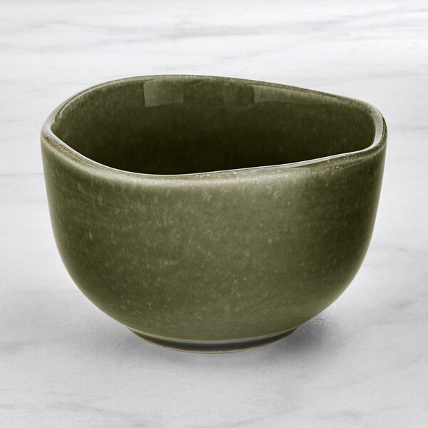 An Acopa Highlands juniper green bowl on a white surface.