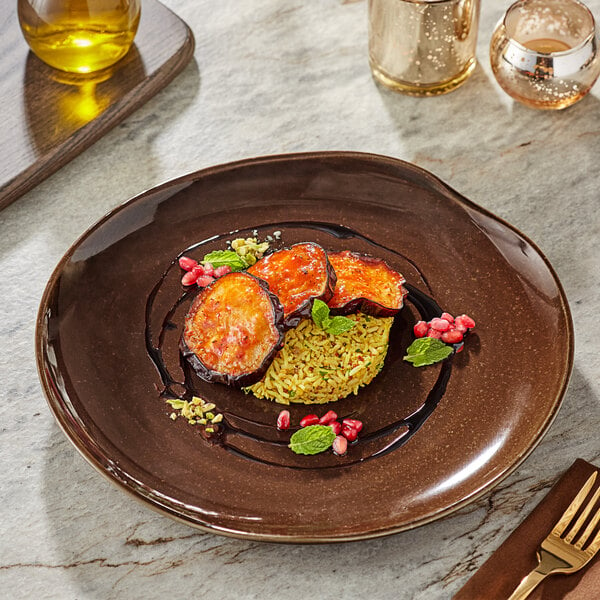 An Acopa Highlands Hazel coupe plate with food, a fork, and a glass of liquid on a table.