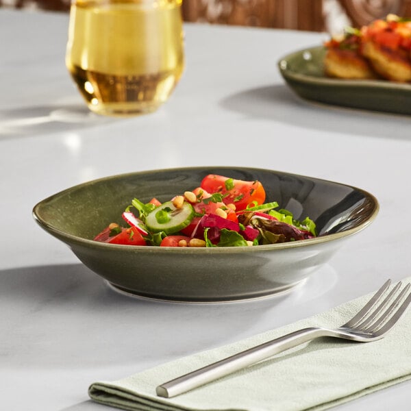 An Acopa Highlands juniper green china bowl filled with salad on a table.