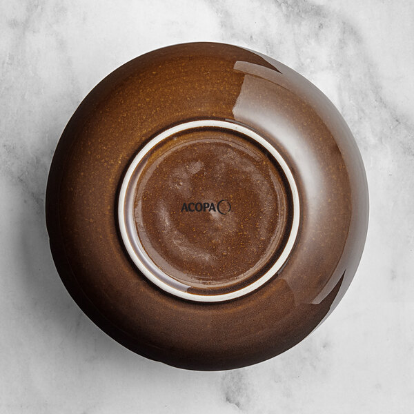 An Acopa Highlands brown china bowl with a white rim on a marble surface.