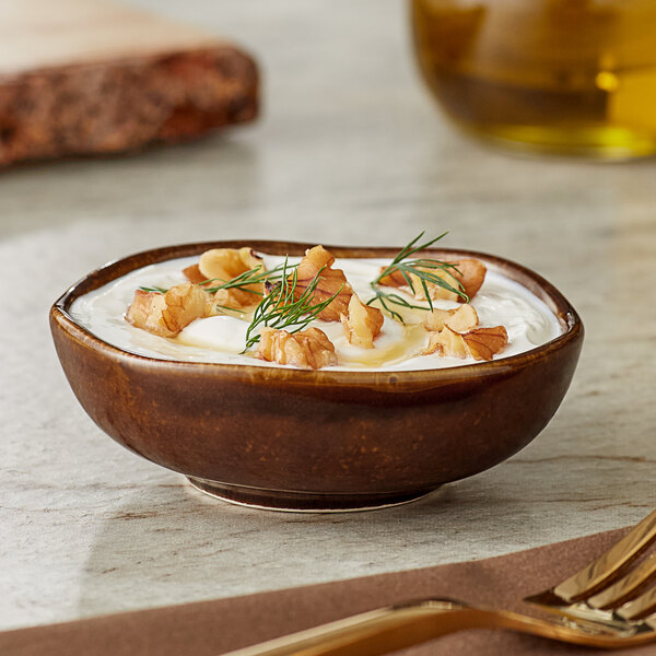 A white bowl of food with a sprig of dill.