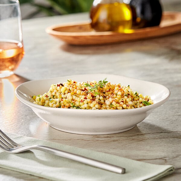 A bowl of food on a table with a knife and fork