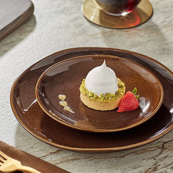 A Acopa Highlands round coupe china plate with dessert and a strawberry on it.