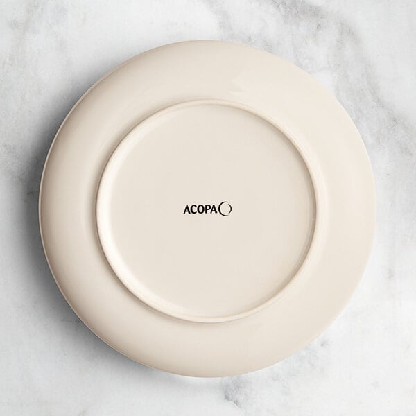 An Acopa Highlands white china plate with black text that says "koska"