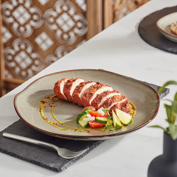 An Acopa Highlands heather gray china plate with sliced meat and vegetables on it.