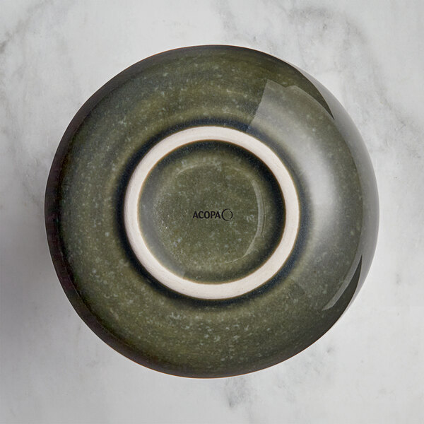 An Acopa Highlands juniper green china sauce cup with a white rim.