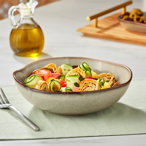 An Acopa Highlands heather gray china bowl filled with pasta, vegetables, and olive oil on a table.