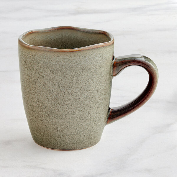 A heather gray Acopa china mug with a handle on a marble surface.