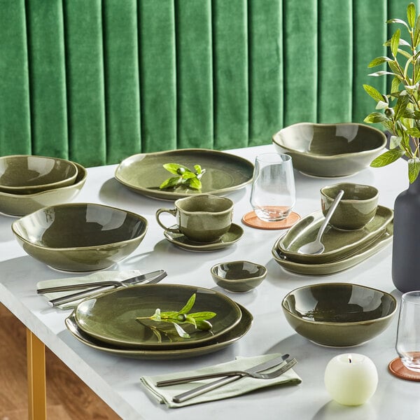 A table set with Acopa Highlands juniper green coupe plates and bowls.