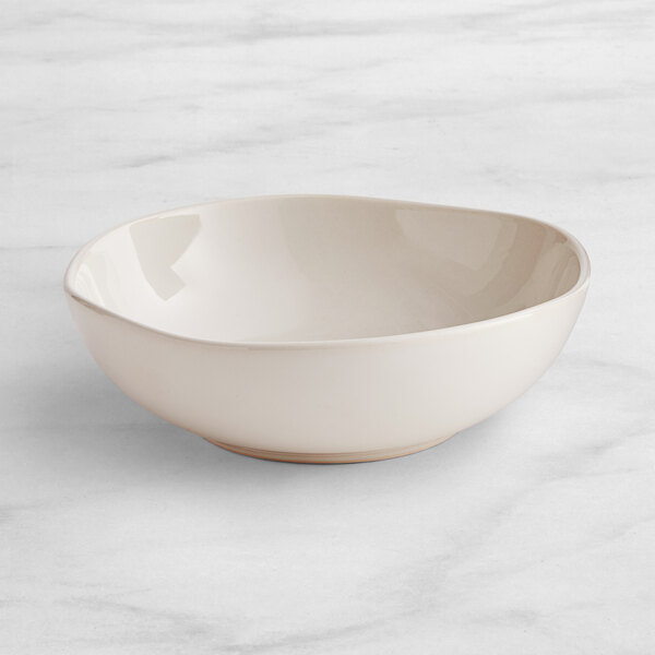 An Acopa Highlands white china bowl on a marble surface.