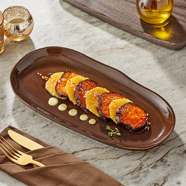 A rectangular brown Acopa china tray with food on a marble table.