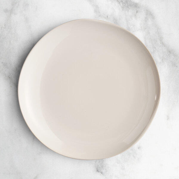 An Acopa Highlands white china plate on a marble surface.