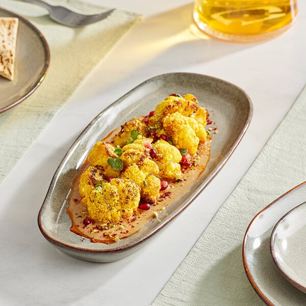 A rectangular heather gray Acopa Highlands china tray with cauliflower and sauce on it.