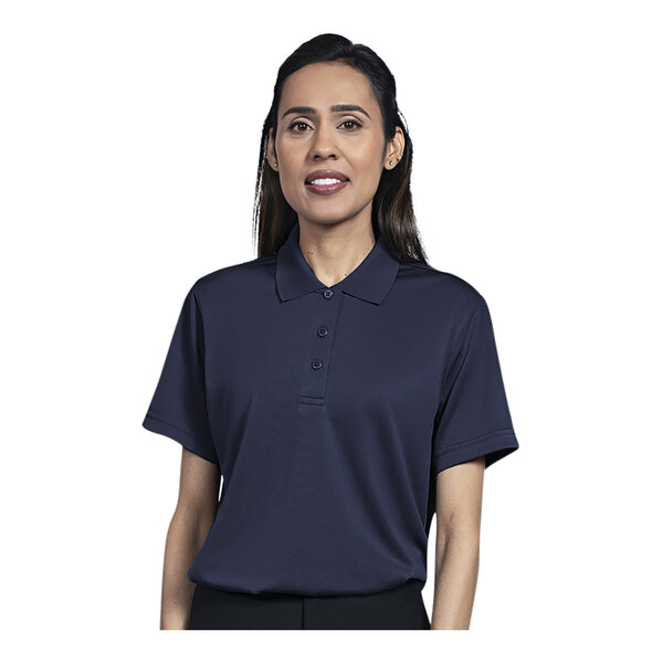 A woman wearing a navy Uncommon Chef short sleeve polo shirt.