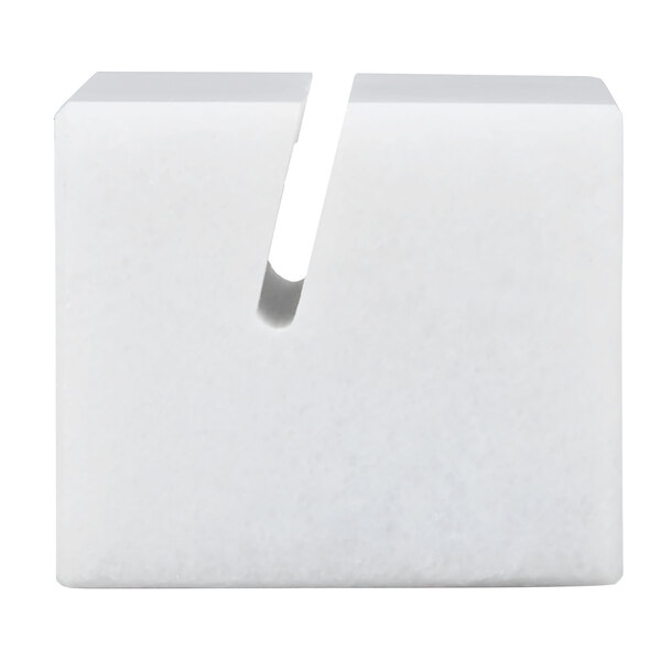 A white, rectangular marble block with a diagonal slot cut into the top surface.