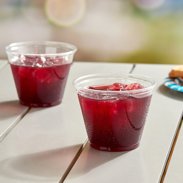 Two Solo plastic cups filled with red liquid on a table.