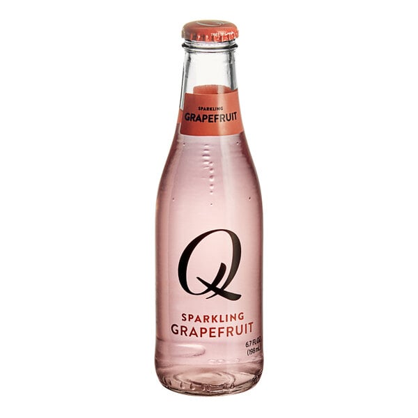 A close-up of a Q Mixers Sparkling Grapefruit bottle filled with pink liquid.