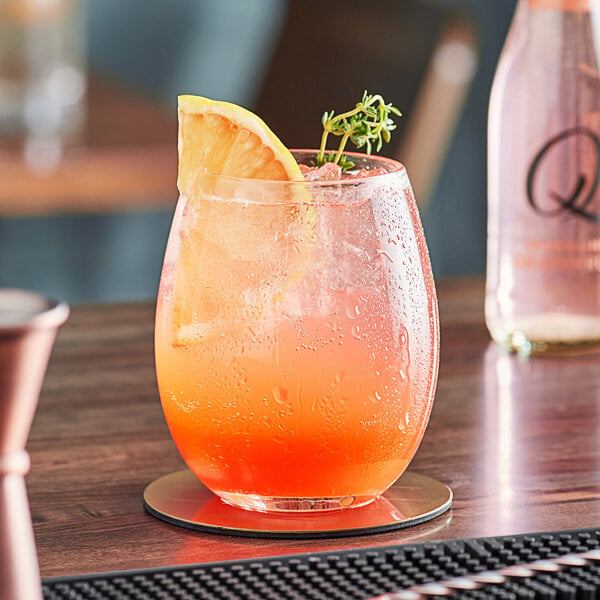 A glass of Q Mixers Sparkling Grapefruit with ice and a slice of orange.