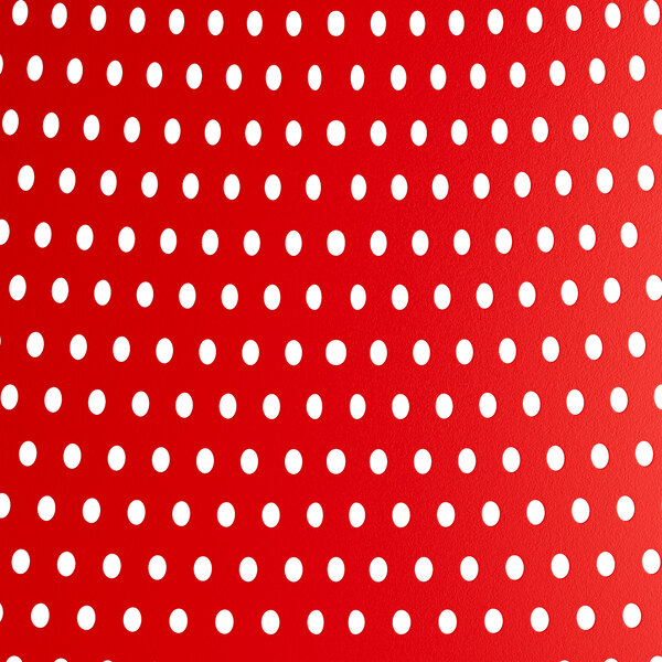 A white background with a red and white polka dot patterned tablecloth on a red Lancaster Table & Seating Rio Buoy resin arm chair.