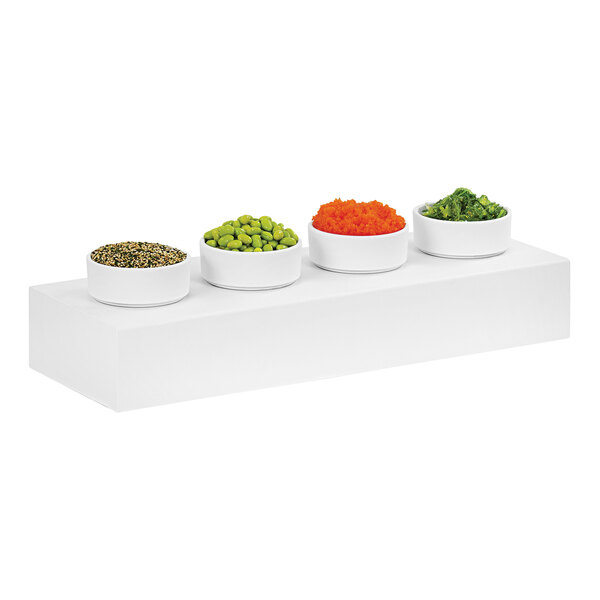A white Cal-Mil rectangle display stand holding bowls of food.