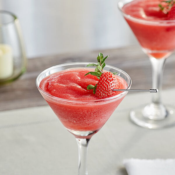 Two martini glasses filled with red drinks with strawberries on top.