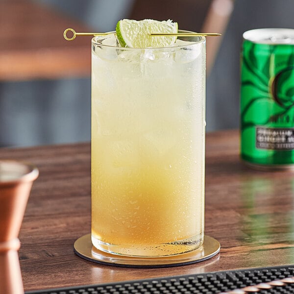A glass of Q Mixers Premium Ginger Ale with a lime slice on a coaster.