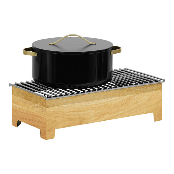A black pot in a Cal-Mil oak chafer alternative on a wooden stand.