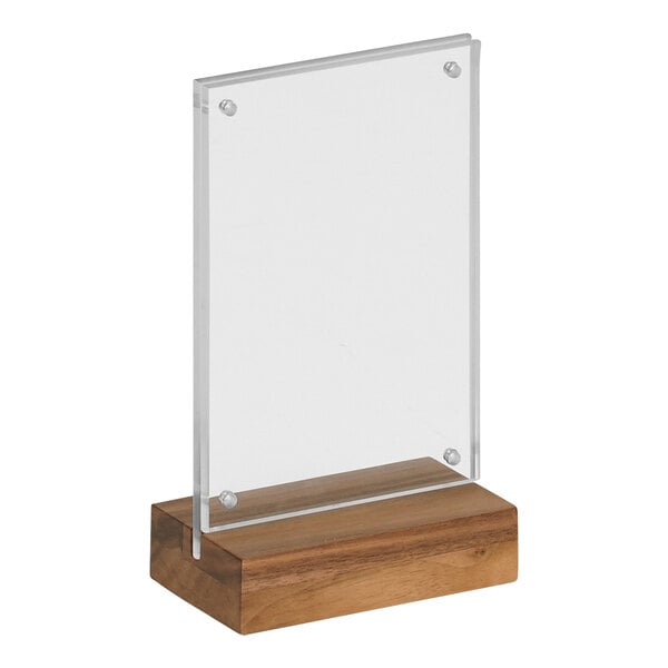 A clear acrylic sign on a wood base with a walnut finish.