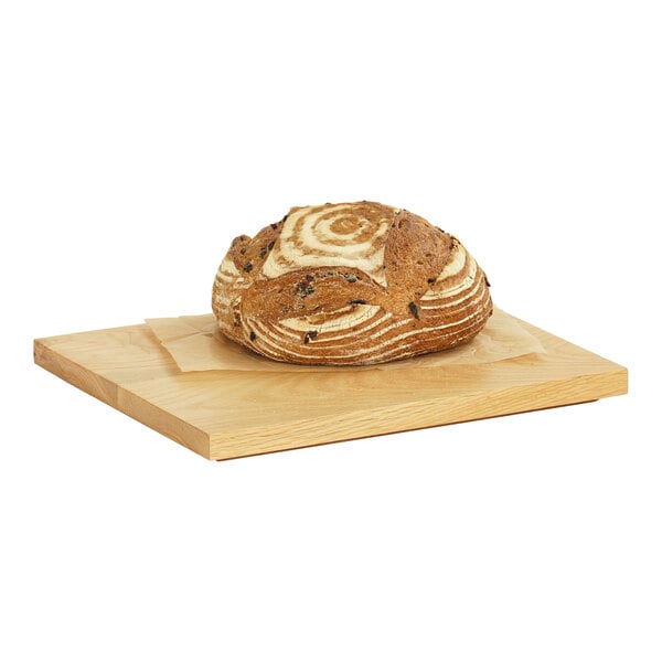 A loaf of bread on a Cal-Mil oak rectangular serving board.