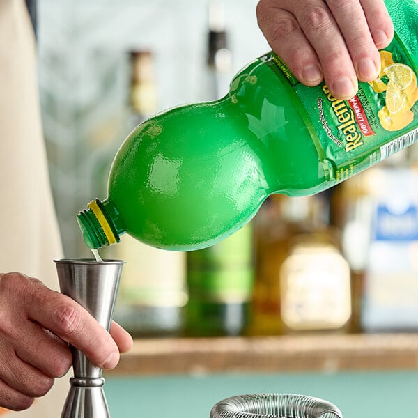 A hand pouring ReaLemon lemon juice into a metal cup.