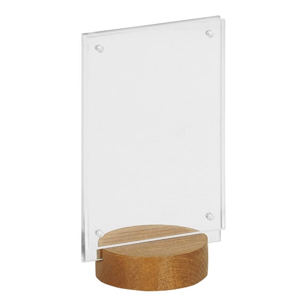 A clear acrylic sign in a wood round base with a slot.